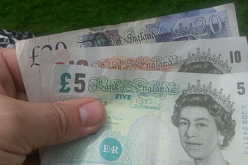 Bank notes Three bank notes (UK money - £5, £10, £20) in hand